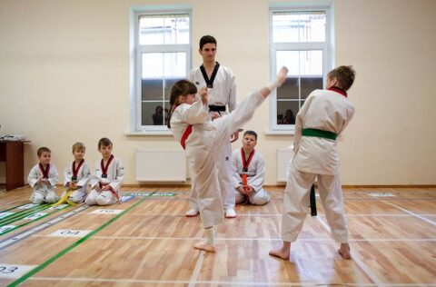 Приватні школи Київ - Ліцей Греміум. Вчимо навчатись! В спортивному залі на уроці фізичної культури дівчина виконує учбовий удар